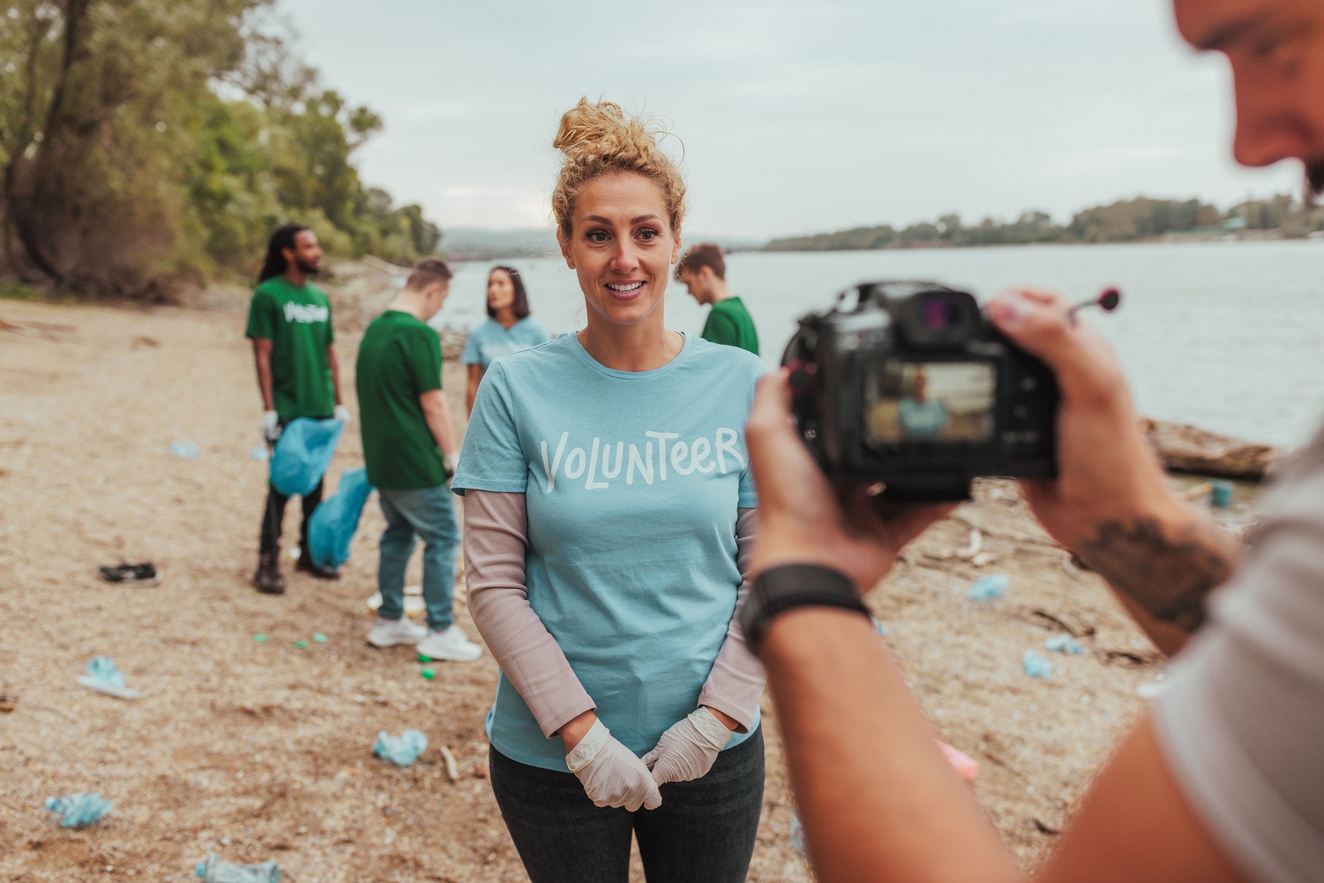 Videographer filming volunteer during river cleanup event